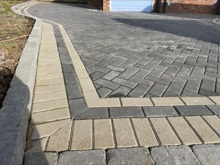 Expansive grey block paving driveway on a large detached property