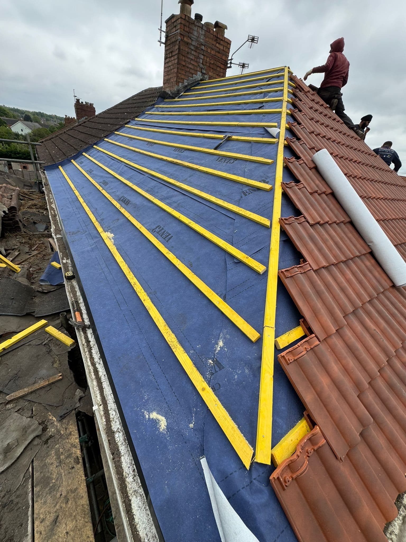 Flat roof installation with dark membrane finish on a terraced property