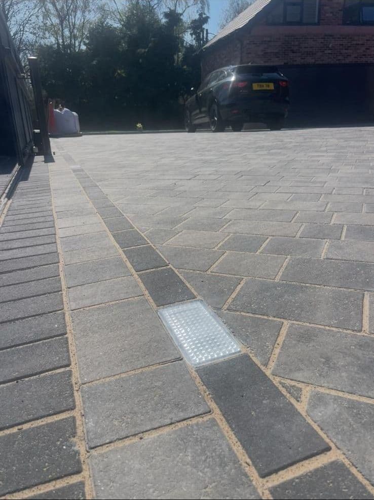 Grey porcelain courtyard patio with composite gate, gravel border, and decking step
