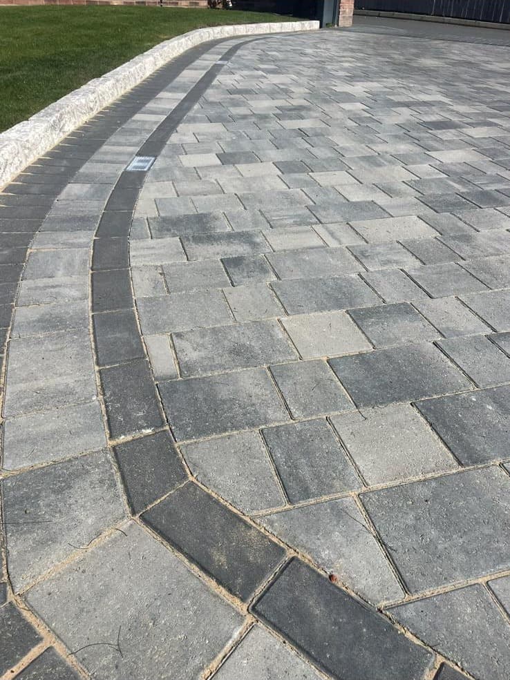 Large-format porcelain slabs laid as a side passage pathway with linear drainage channel